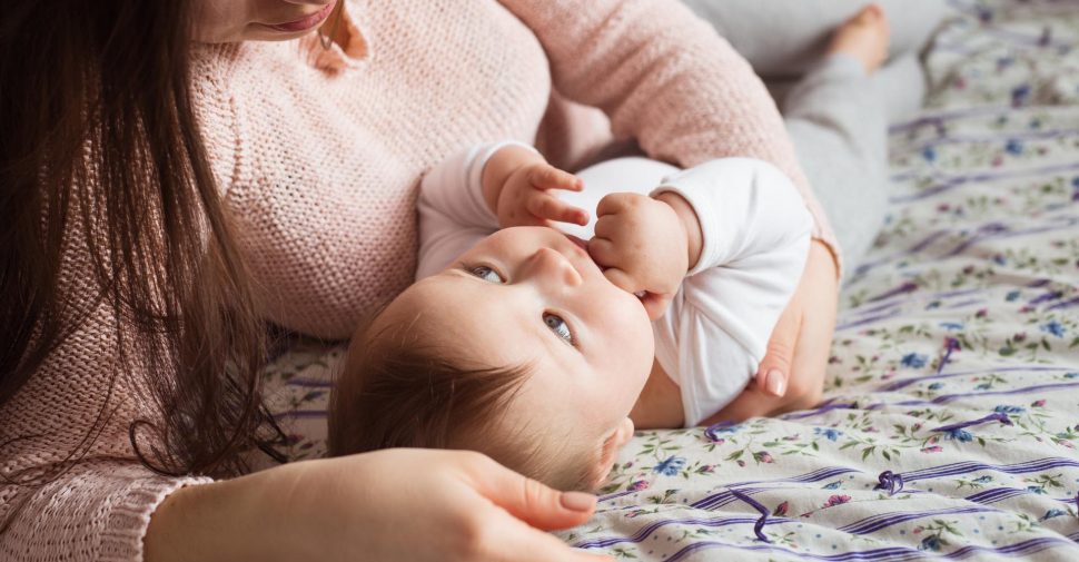 A Mother and baby child on a bed.